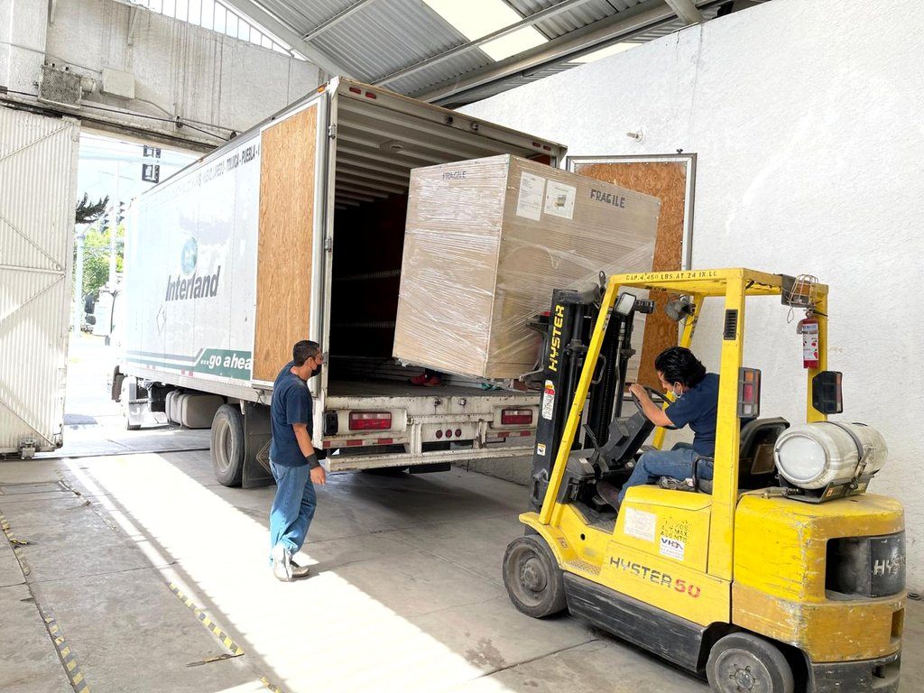 Montacargas cargando equipo embalado en un camión
